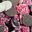 Close-up of chocolate cookies with pink and white sprinkles.