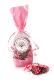 Pink gift bag with chocolate candies and a visible brand logo on a white background